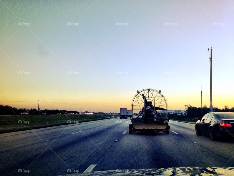 Air boat being hauled on highway