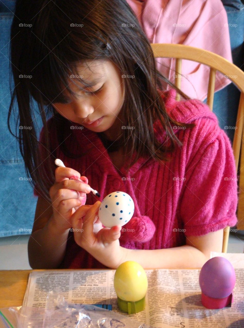 Girl decorating easter egg