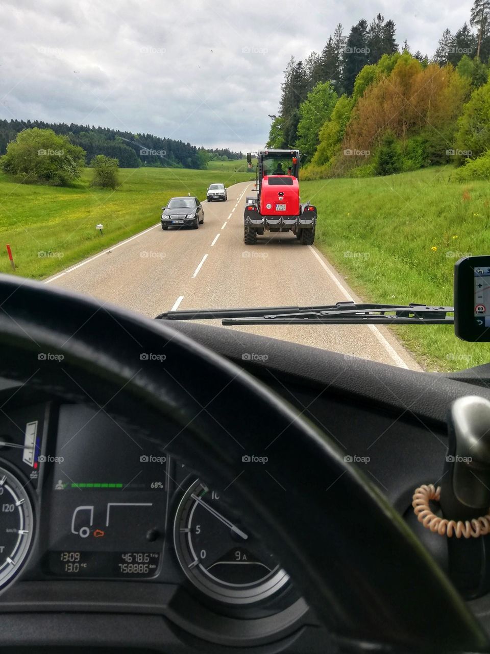 Red tractot in front of the truck.