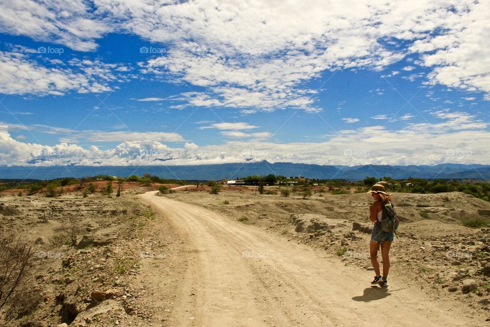 Girl walking on dirt trail through the desert