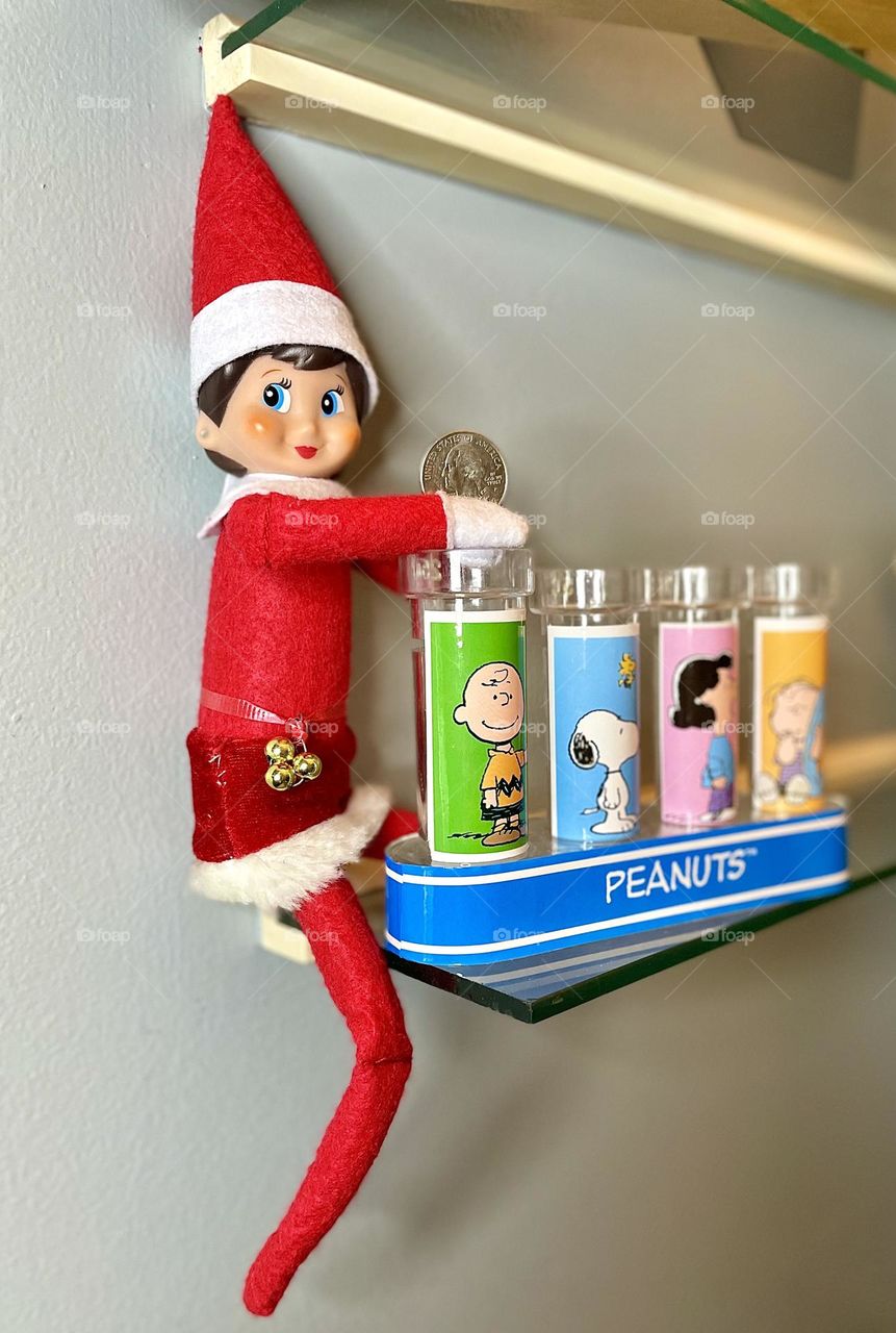 Elf on the shelf saves money, elf on the shelf antics, elf on the shelf puts coins in sorter, using a coin sorter to save money, elf on a shelf shows kids how to save money