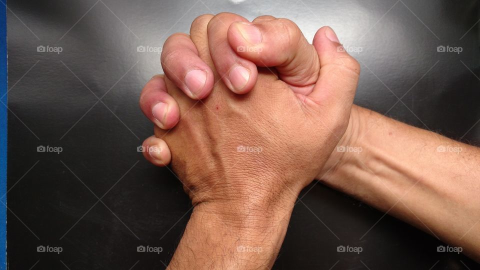 Mãos esquerda e direita em ação! Segurando firmes com  os dedos cruzados em forma de cumprimentos.