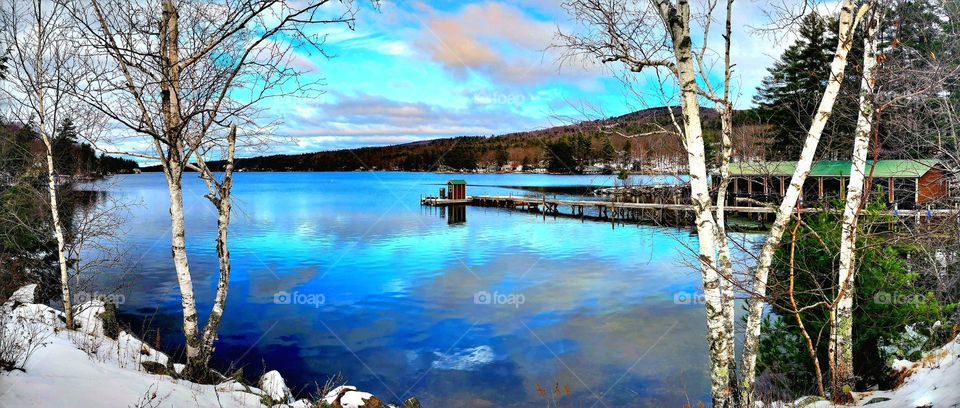 A winter scene from Lake Sunapee in New Hampshire has shades of rich blues in the sky and reflected on the lake