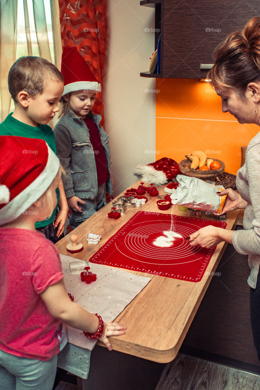 Baking Christmas cookies. Christmas gingerbread cookies in many shapes decorated with colorful frosting, sprinkle, icing, chocolate coating, toppers, put on table. Baking traditional cookies. Family celebrating Christmas. Baking at home