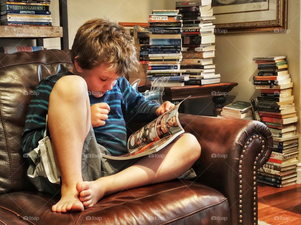 Boy Reading Surrounded By Stacks Of Books