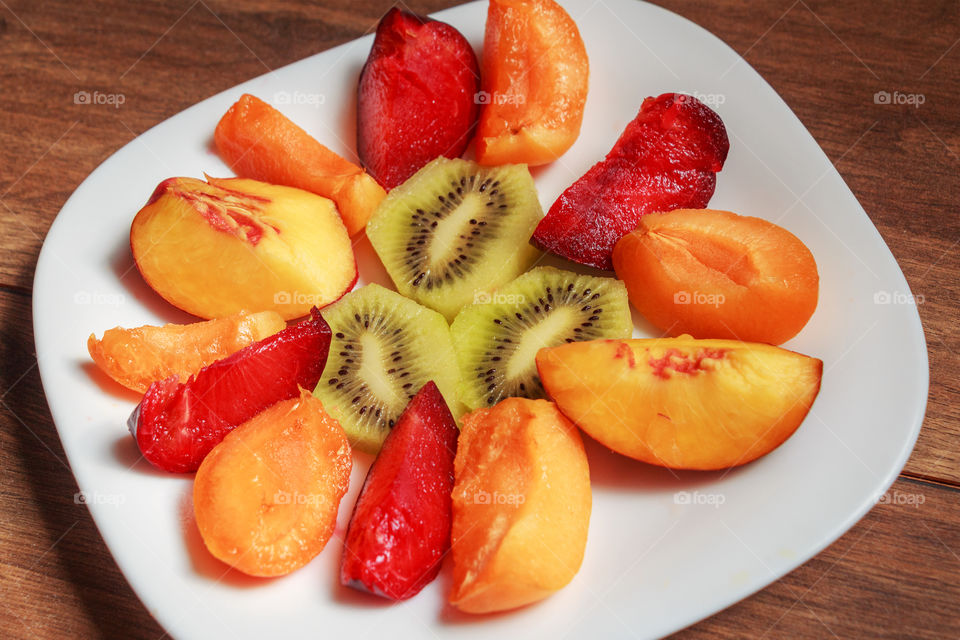 Fruit salad of apricot, blue plum, kiwi and peach