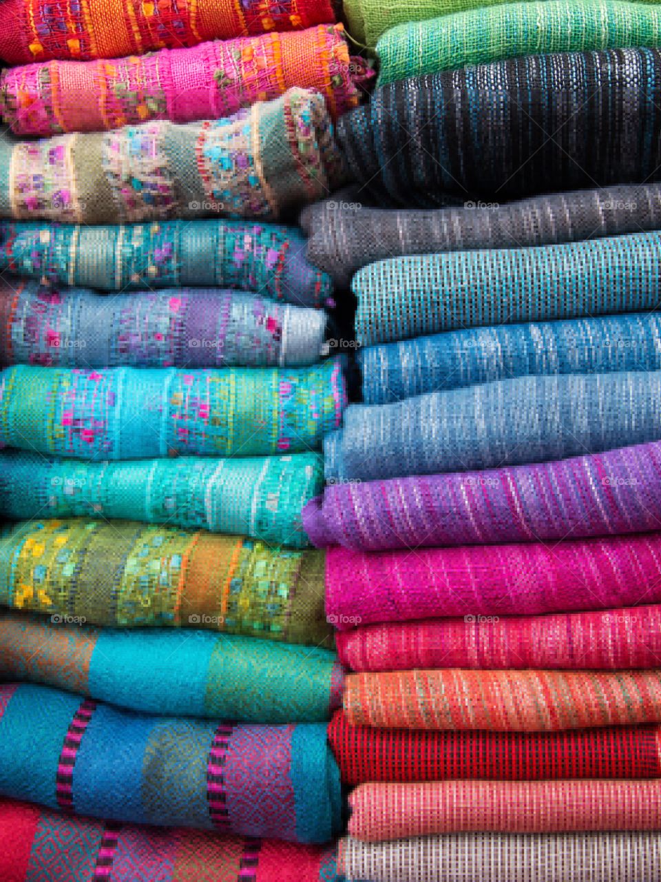 Stacked and folded colorful shawls
