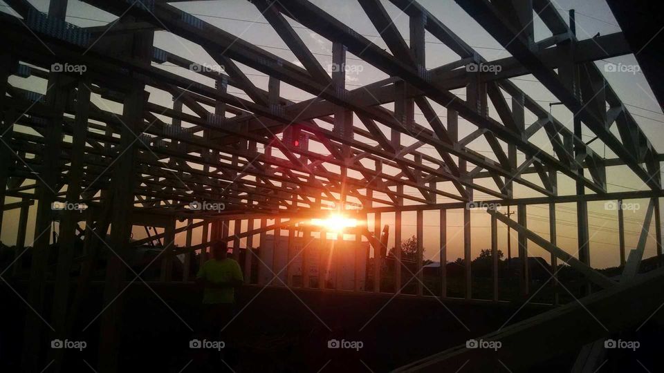 beautiful sunset behind a home in the early stages of constuction