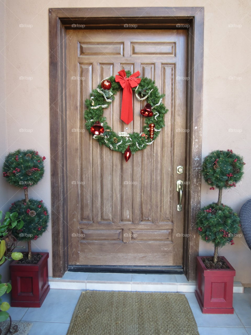 Christmas doorway with wreath and topiaries.