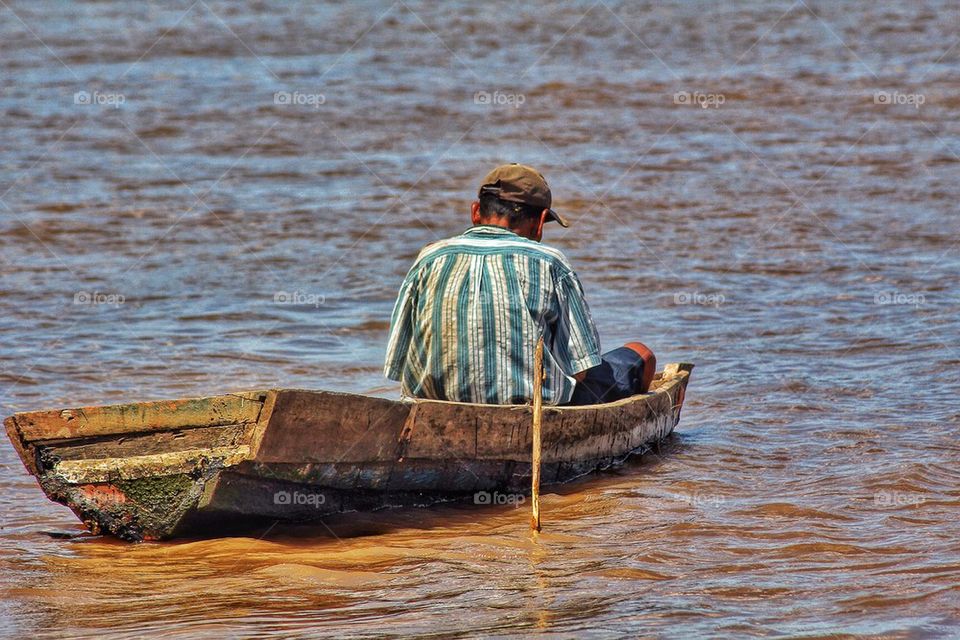Rear view of man sitting in old boat