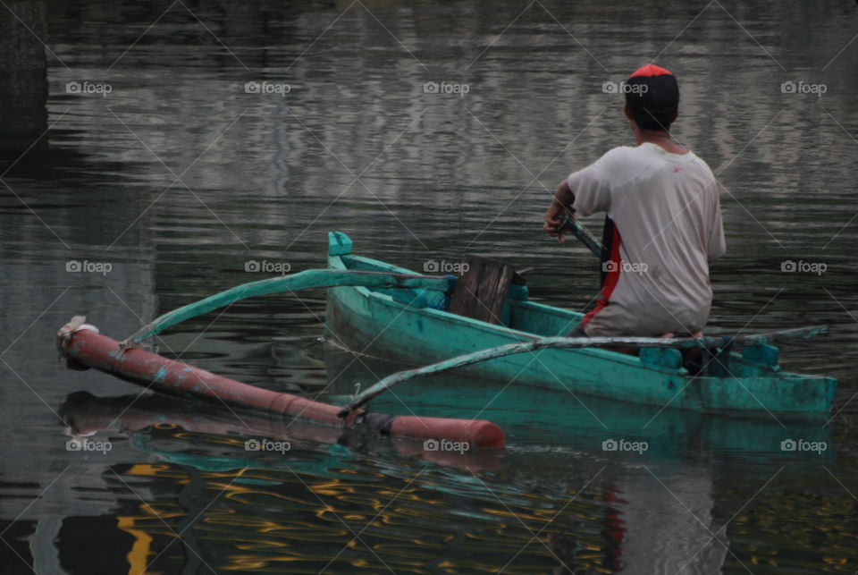 Person of man for his interest to drive on a manual watercraft . Slowly for salt water from the harbour of district's.