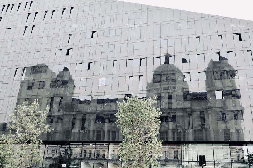 Reflection of an old architecture building on new mirrored building Liverpool uk