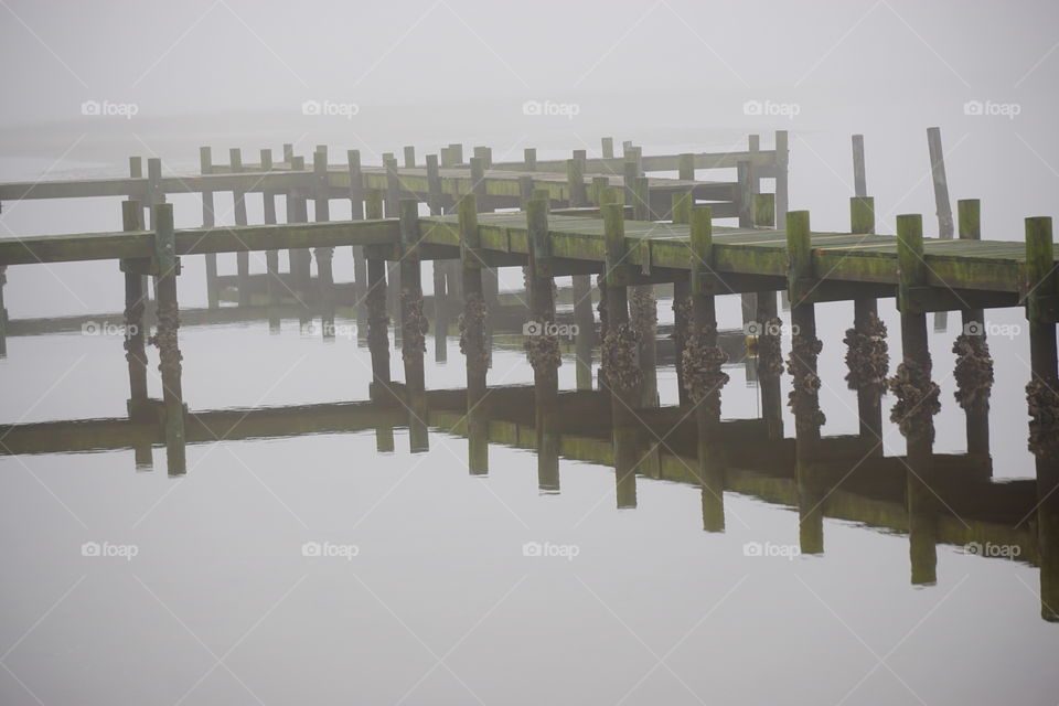 Reflection of wooden pier in sea