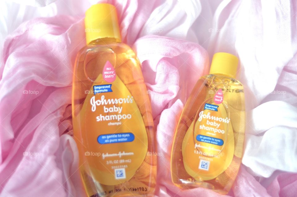 Johnson and Johnson baby shampoo on a pink background flat lay 