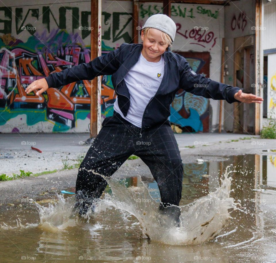 Dancing boy into the streets . He feel the beat and even its raining ,he dancing in the rain