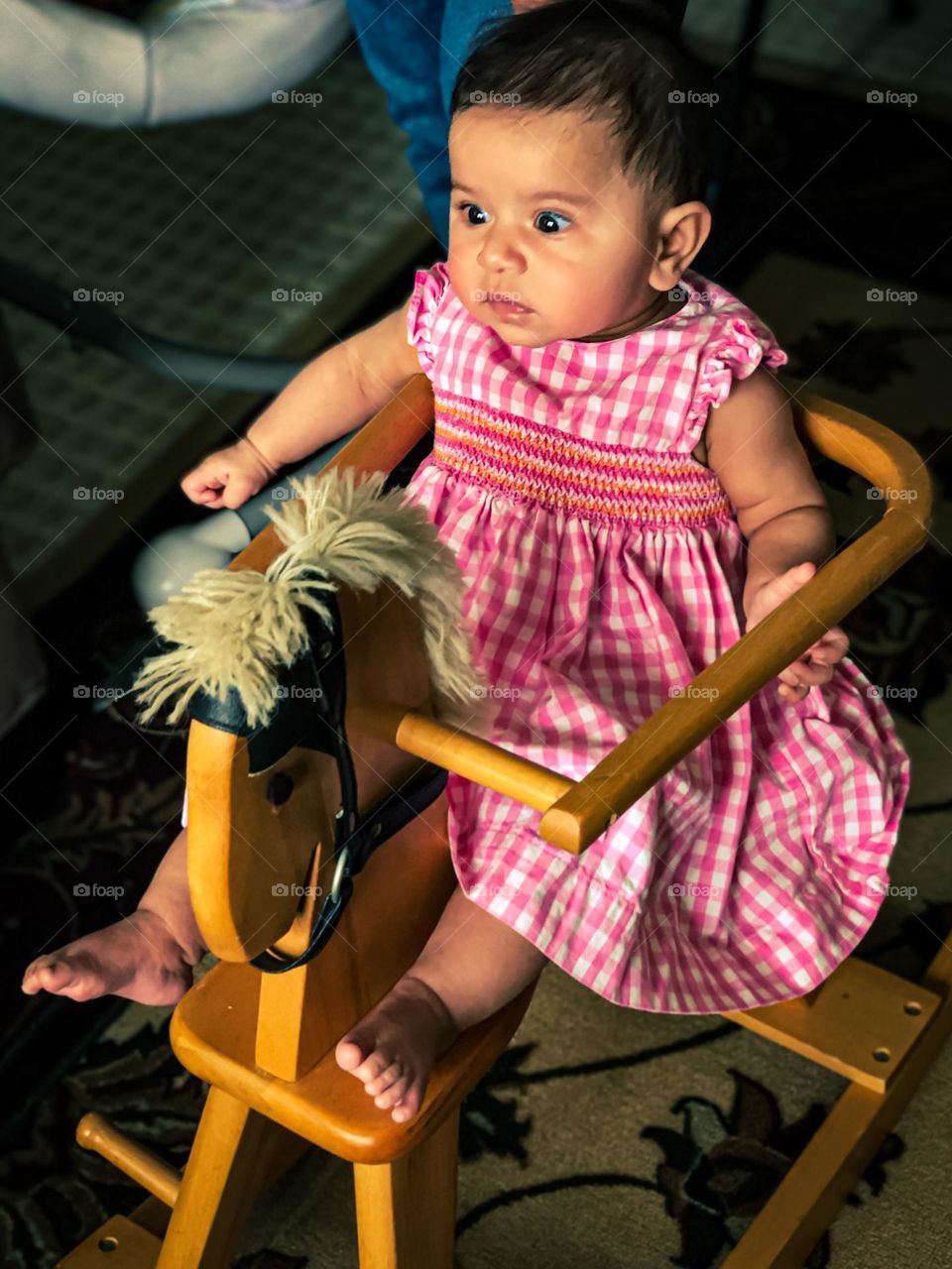 Surprised baby riding on rocking horse, baby with surprised face, baby with funny surprised face, wide eyed baby face, baby riding riding on rocking horse, baby girl showing emotion of surprise 