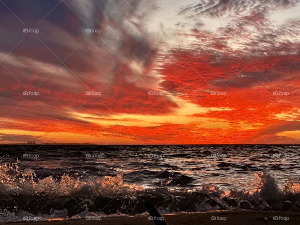 A breathtaking and radiant sunset which colors the waves iridescent, often towers and collides the shore with great force. The impact of the waves against the coastline created a stunning display of energy and motion