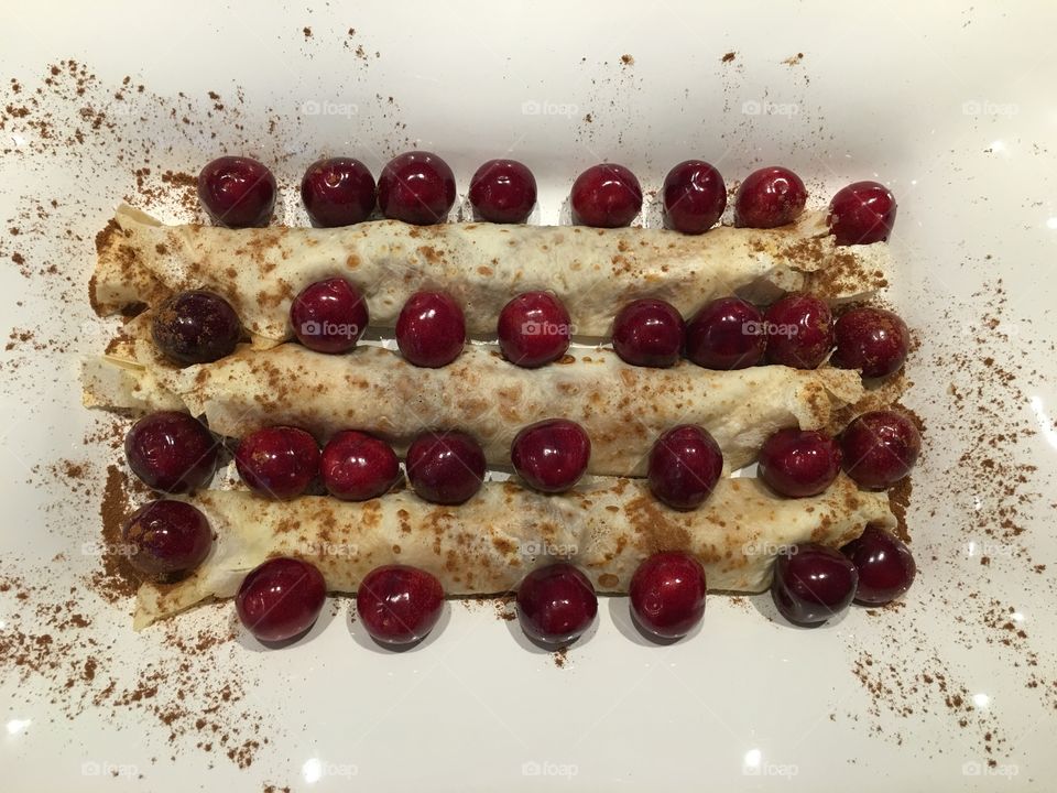 Homemade crepes with honey/ walnuts filling , with cherries  in between  
