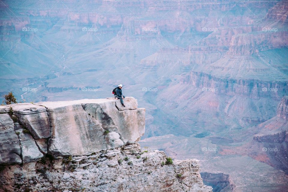 Guy sitting at the edge of grand canyon