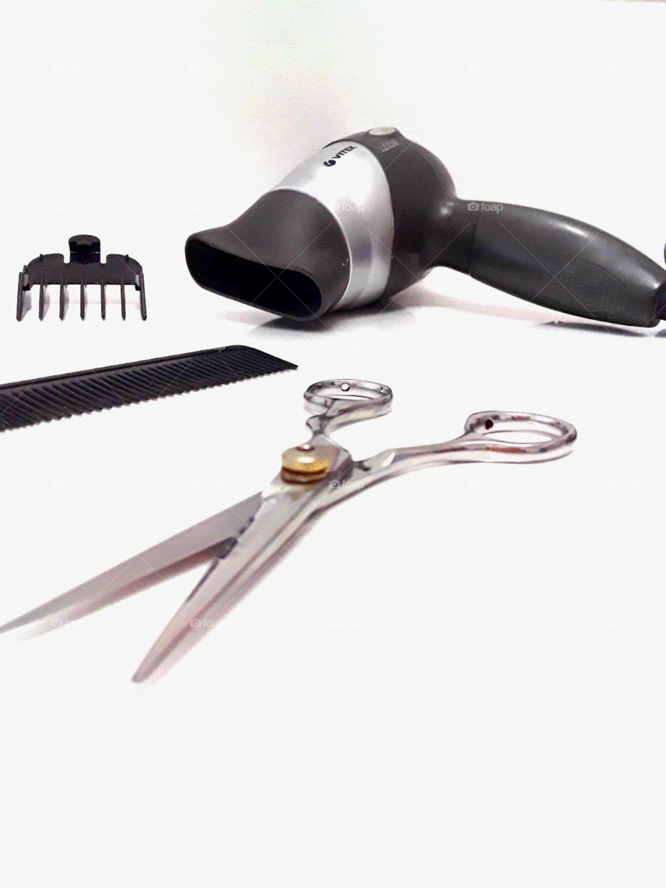 hairdryer, comb, scissors all on a white background