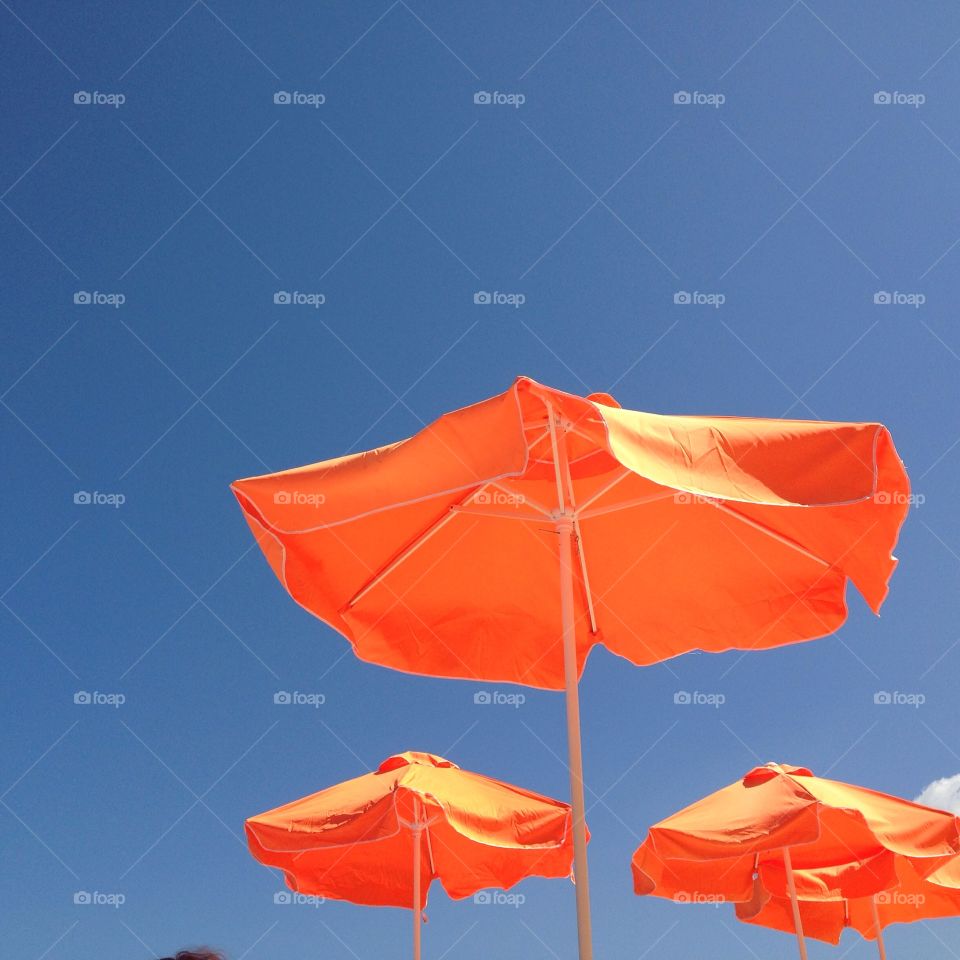 Sun parasol umbrellas against blue sky summer vacation