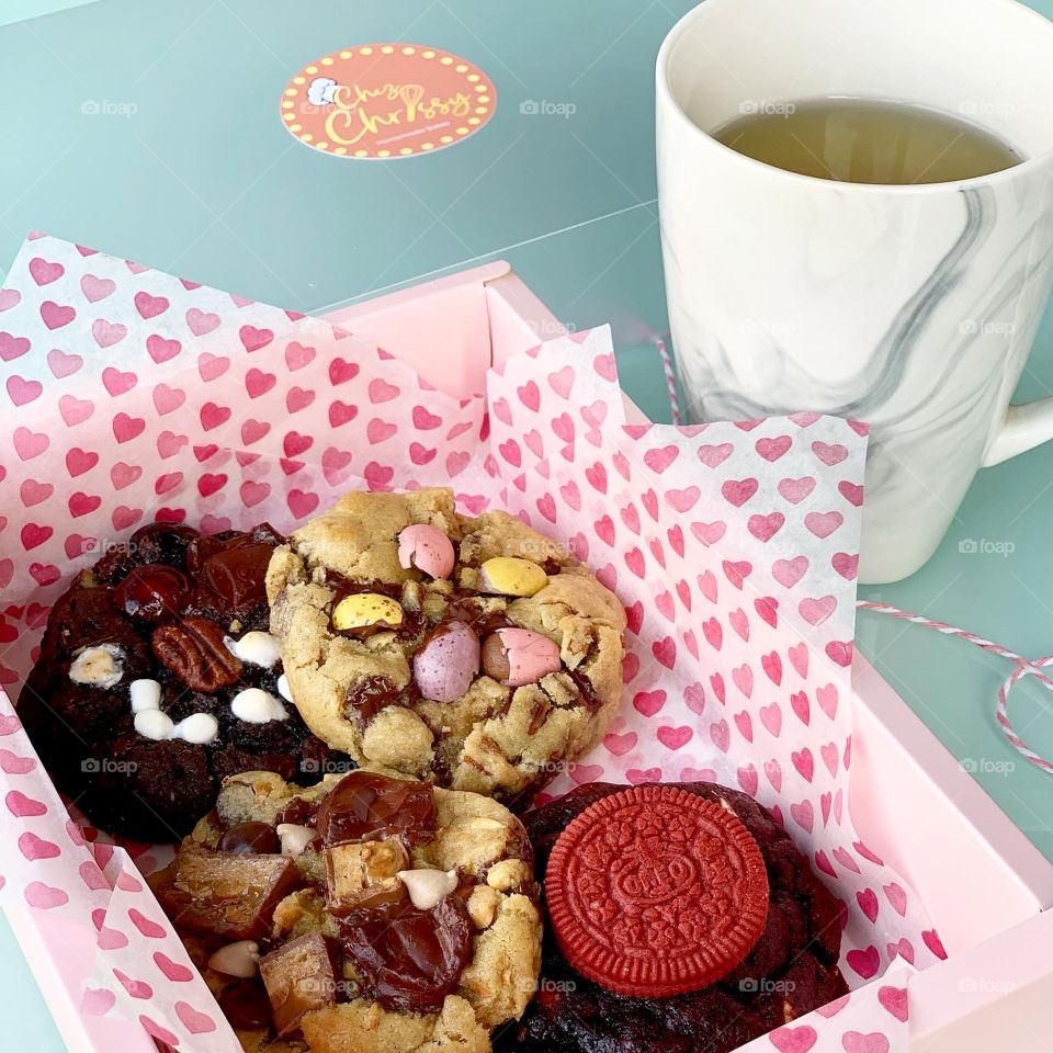Freshly baked Gooey Easter cookies in chocolate in big chunk with hot tea for afternoon snack 