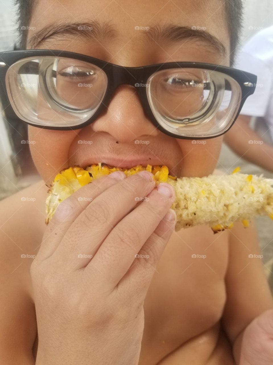 Child Eating yummy crunchy roasted corn on the cob in El Salvador
