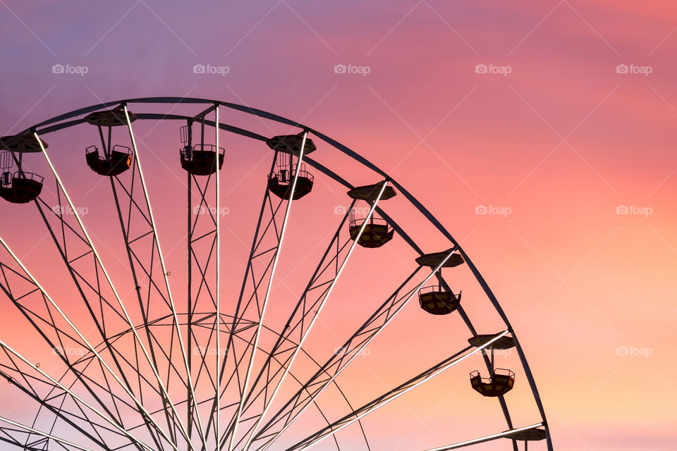 Pink sunset with ferris wheel silhouette