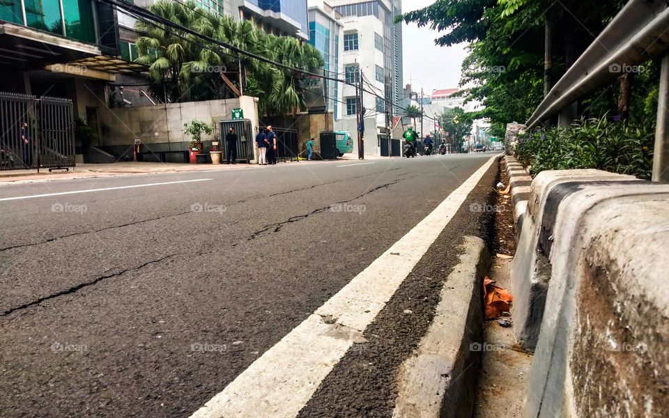 Photo of a road with no vehicles and full of trees