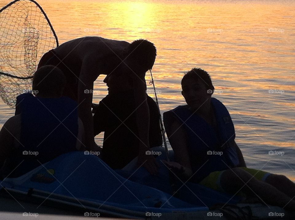 Youth silhouette on lake. Youth silhouette fishing on lake at sunset