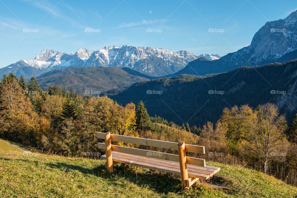 Empty bench against mountains