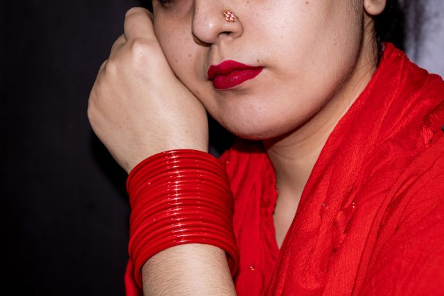 women in the red lady wearing all red her suit her lipstick and her bangles all in indian attire