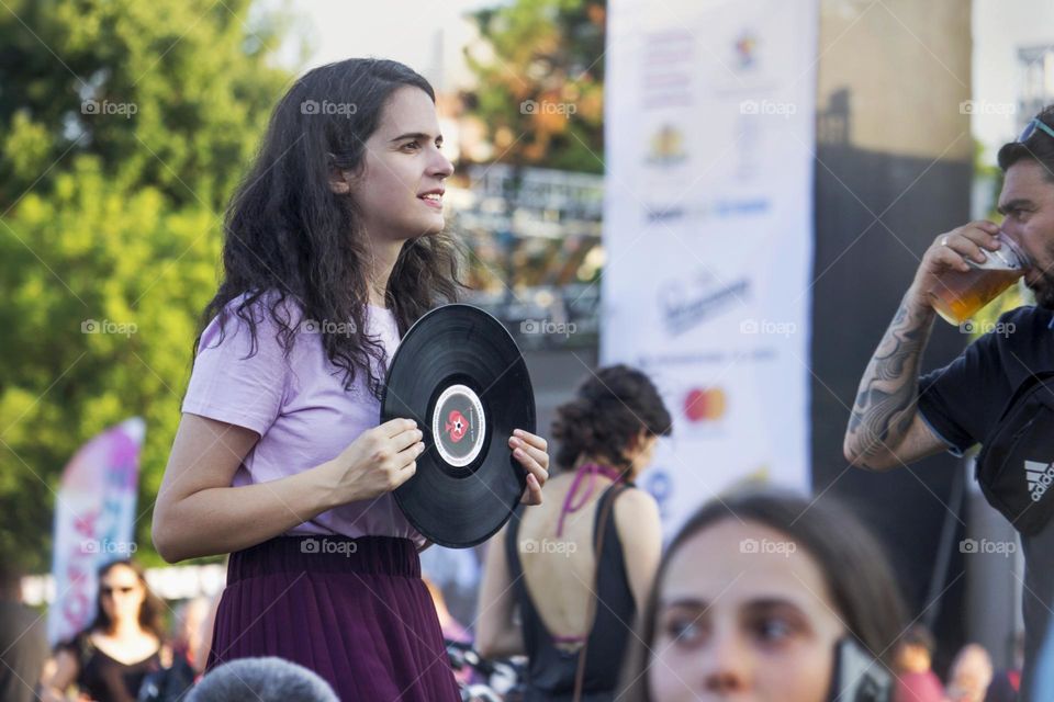 Young woman in the crowd holds vinyl