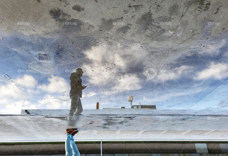 The mirror on a rainy day at the metro station looks like someone is walking on the beach