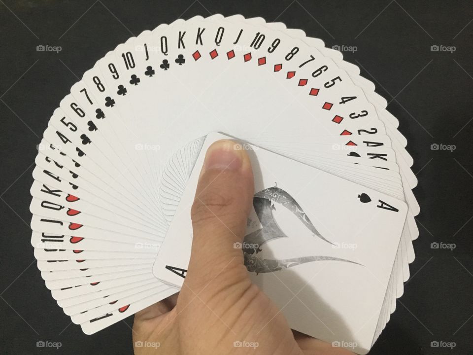 Playing cards in hand on black background