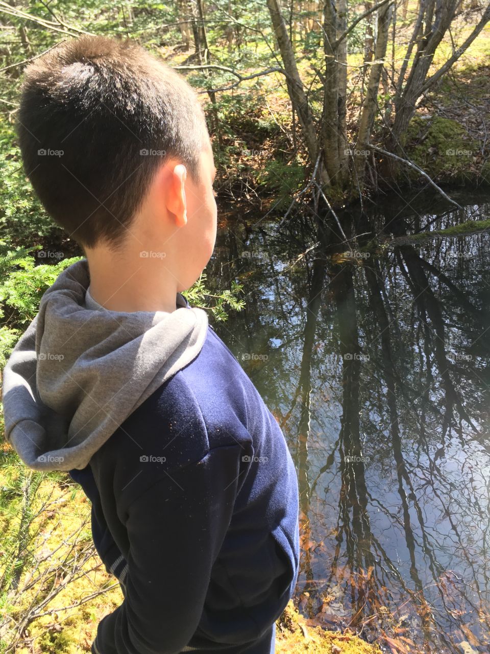 Boy hiking finds a pond