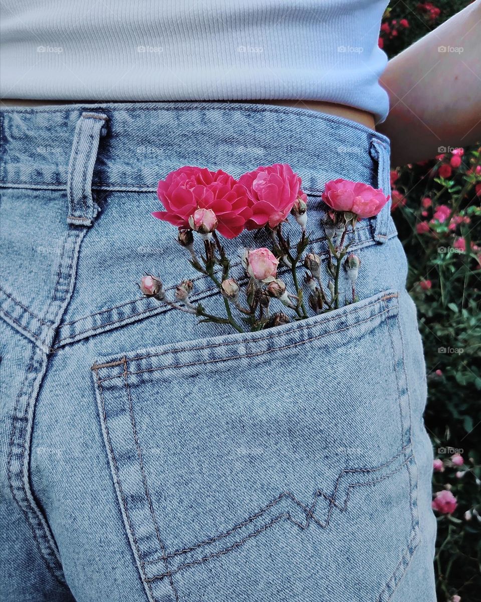 In contact with nature. Flowers in a jeans pocket. Aesthetics of human with nature.