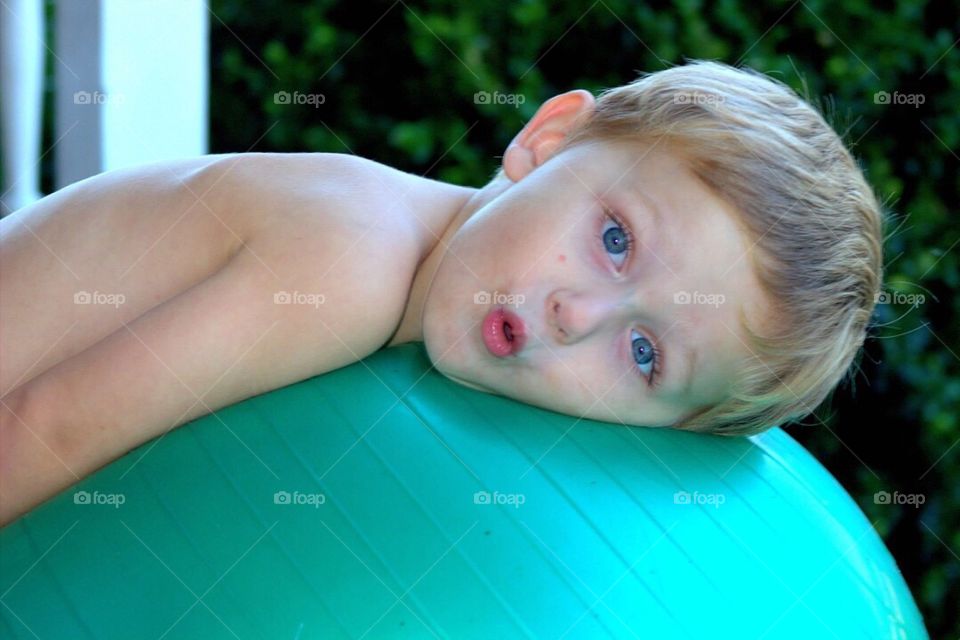 Boy lying on pilates ball