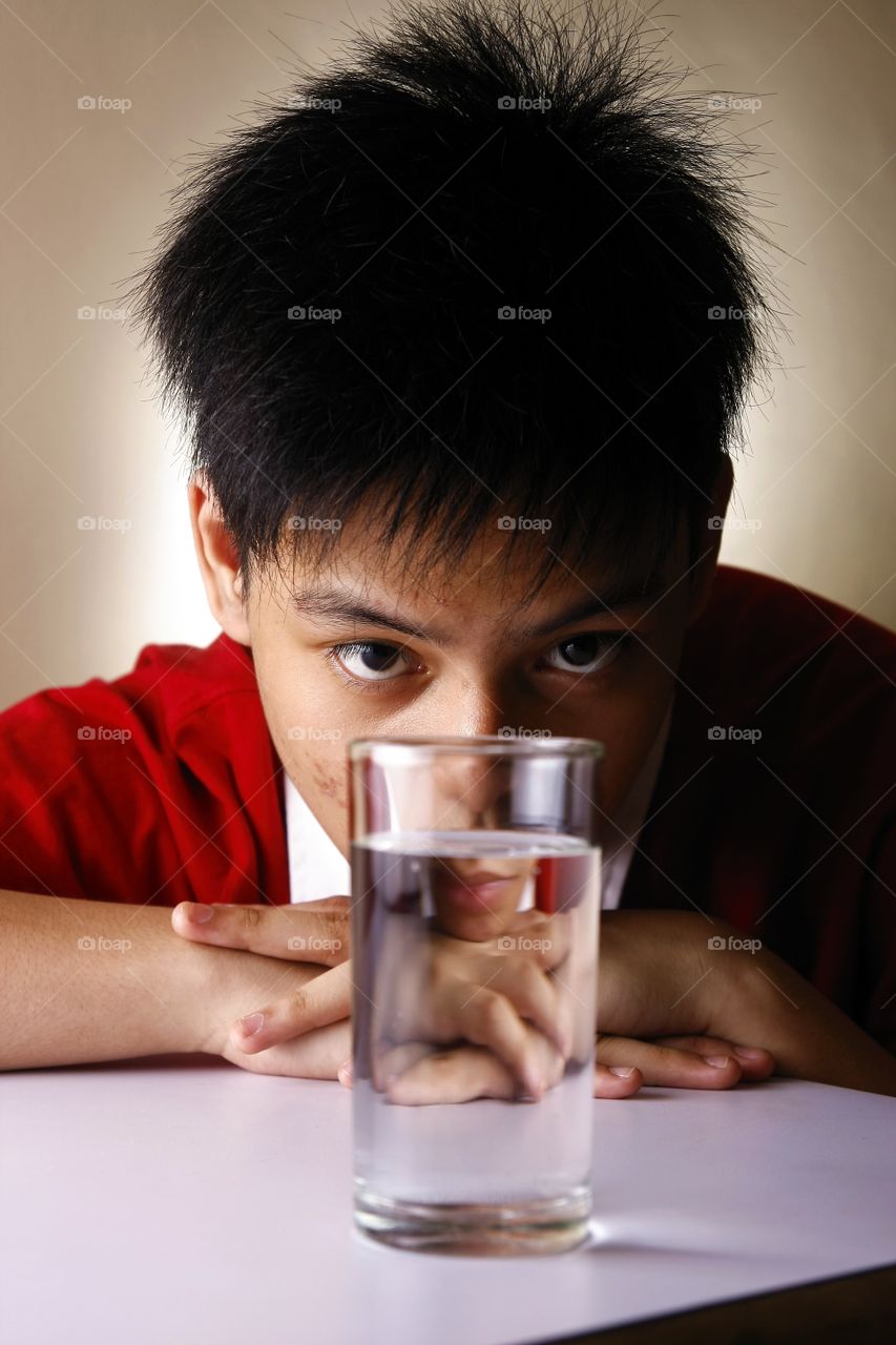 teen boy looking at a glass of water