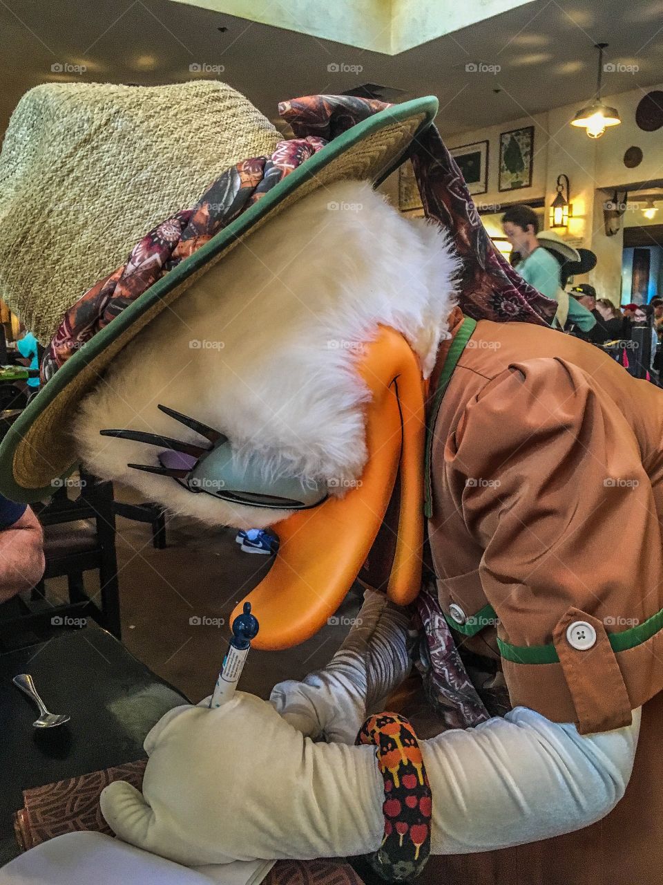 Daisy Duck concentrating on signing her autograph.  This was in the Animal Kingdom hence the safari outfit.