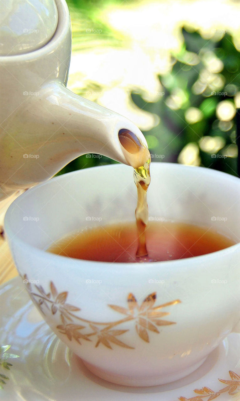 Hot tea pouring in a cup