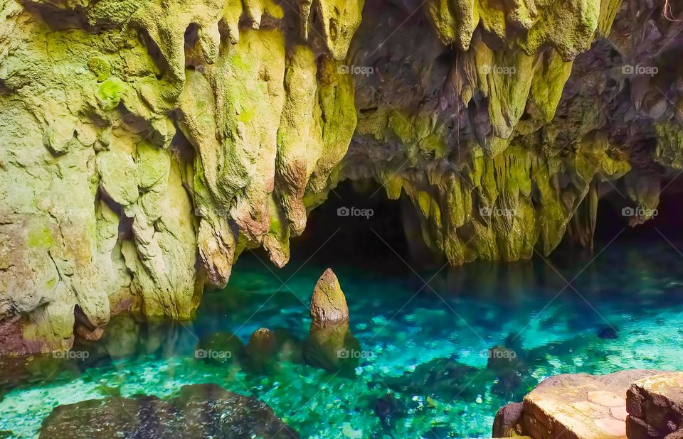 The enchantment of a mystical stone in the blue water in Hawang Cave