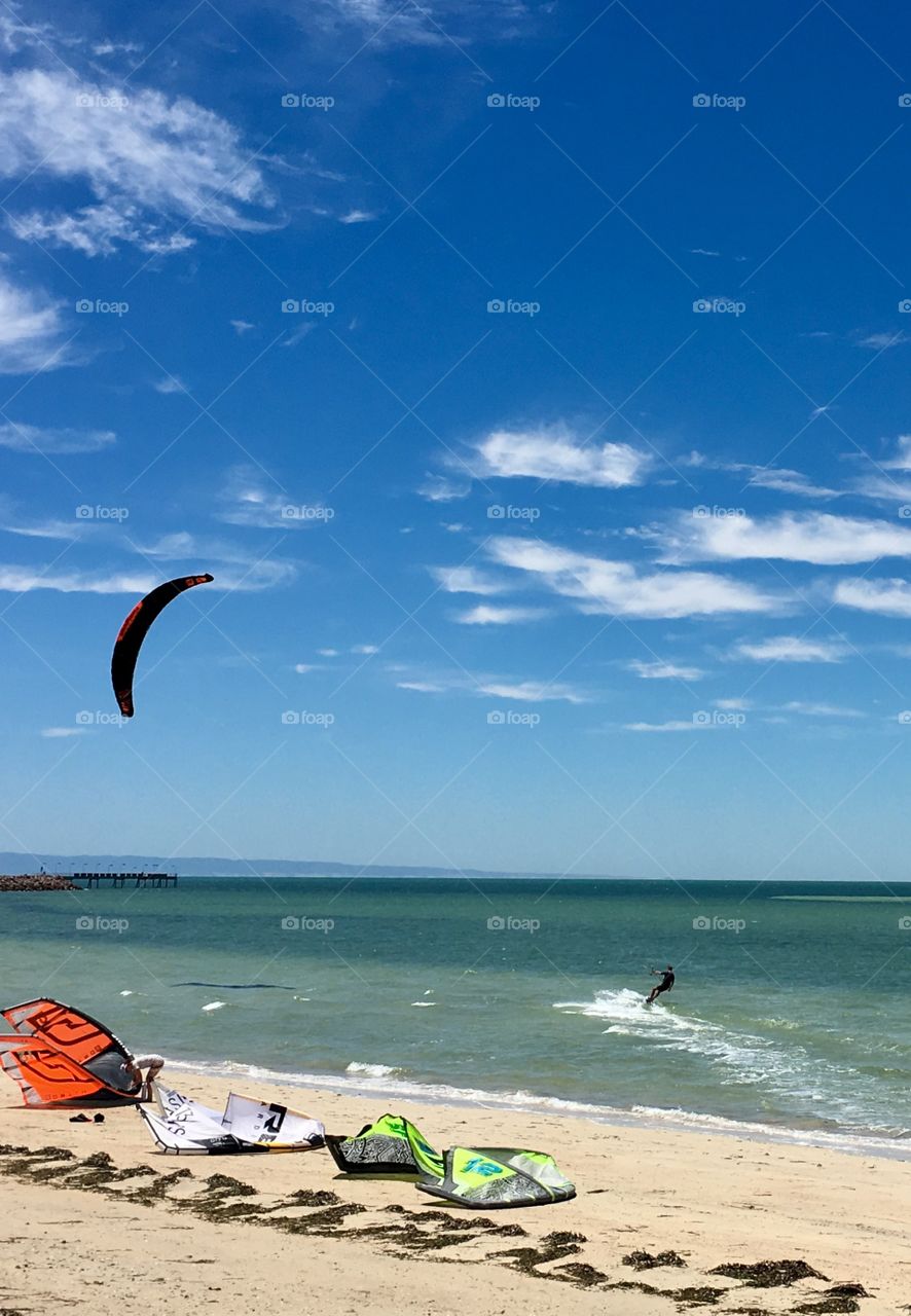 Skimming along the shoreline on a breezy day, kiteboarding 