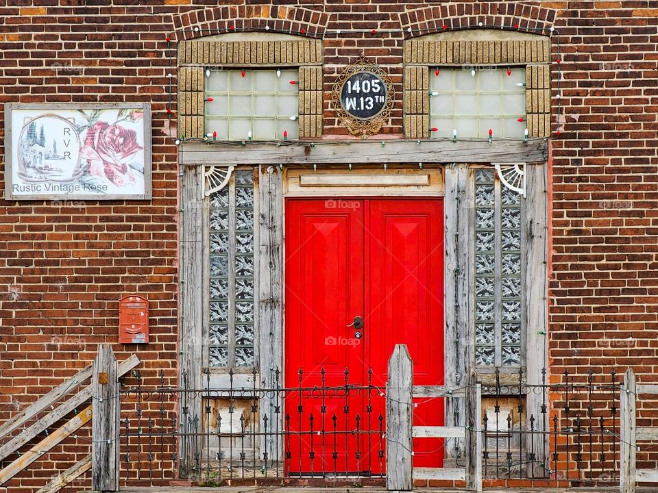 A bright red door contrasts the dull surrounding exterior and creates a rectangular space