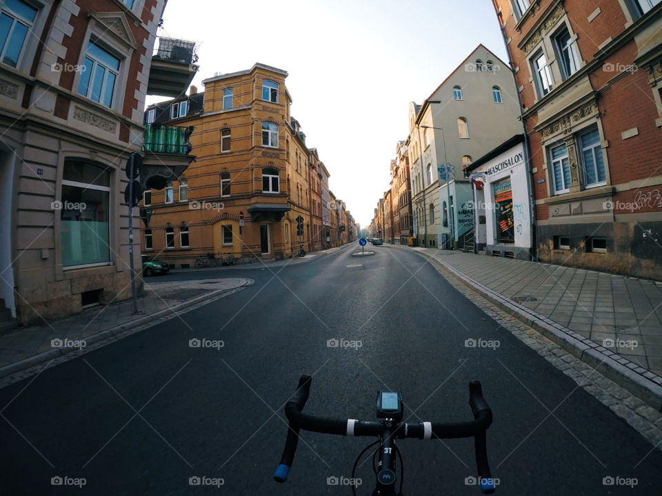 morning ride with roadbike through empty streets of a german city. it's summer, the sky is blue.