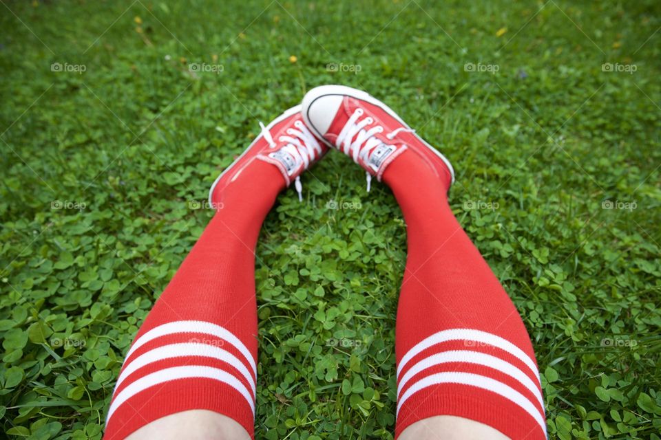 Red socks and shoes on green grass