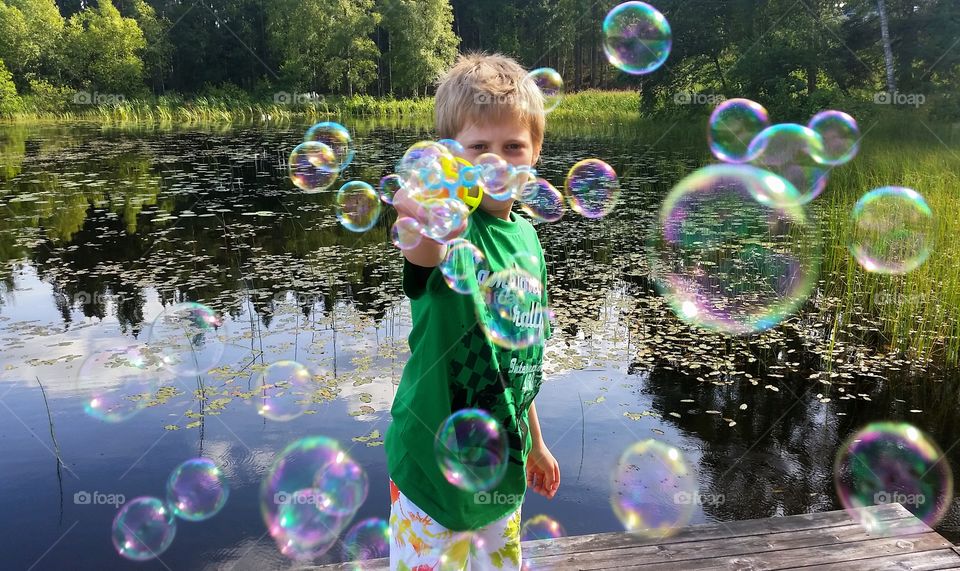 Boy playing with soap bubbles machine