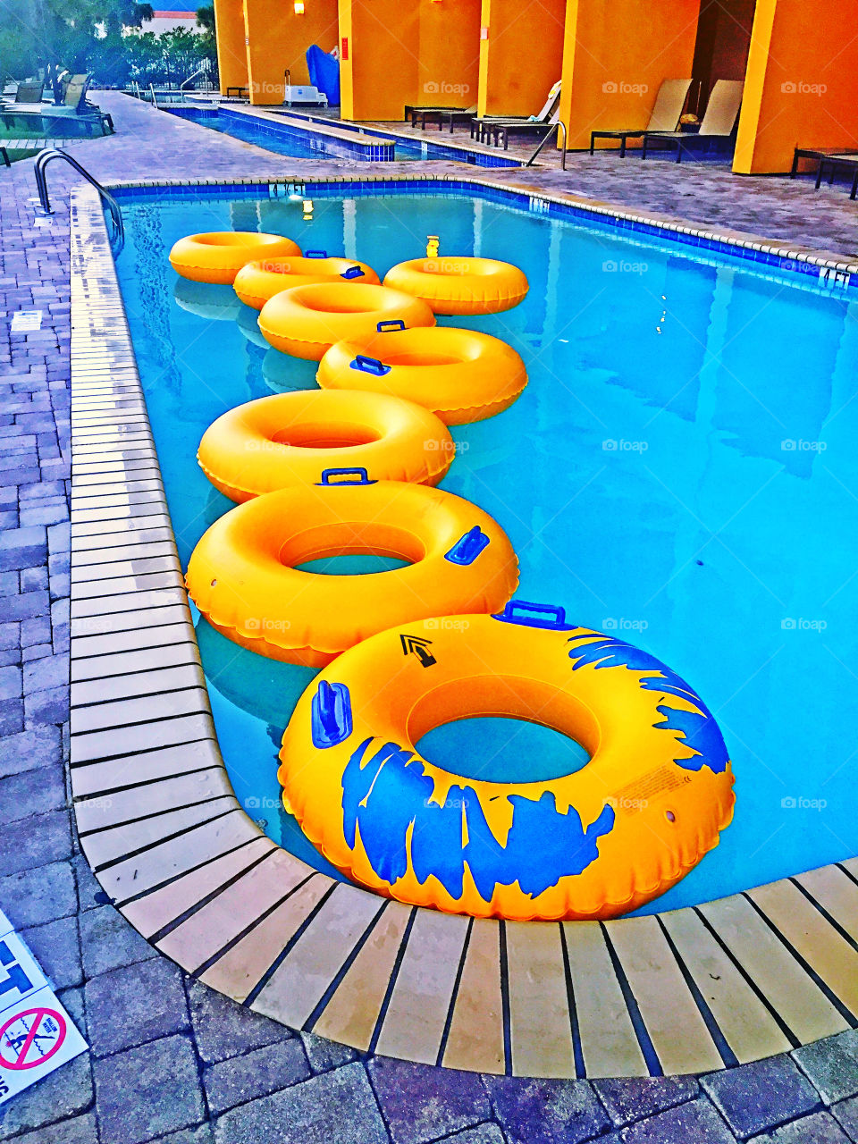 Yellow pool rings float in a swimming pool. 