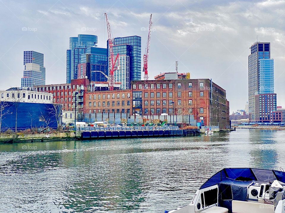 A large brownstone building on the Greenpoint, Bklyn side of the shore at Newtown Creek in Long Island City, Queens, NY photographed under a partially overcast day in December 2021. Hypnotic Productions