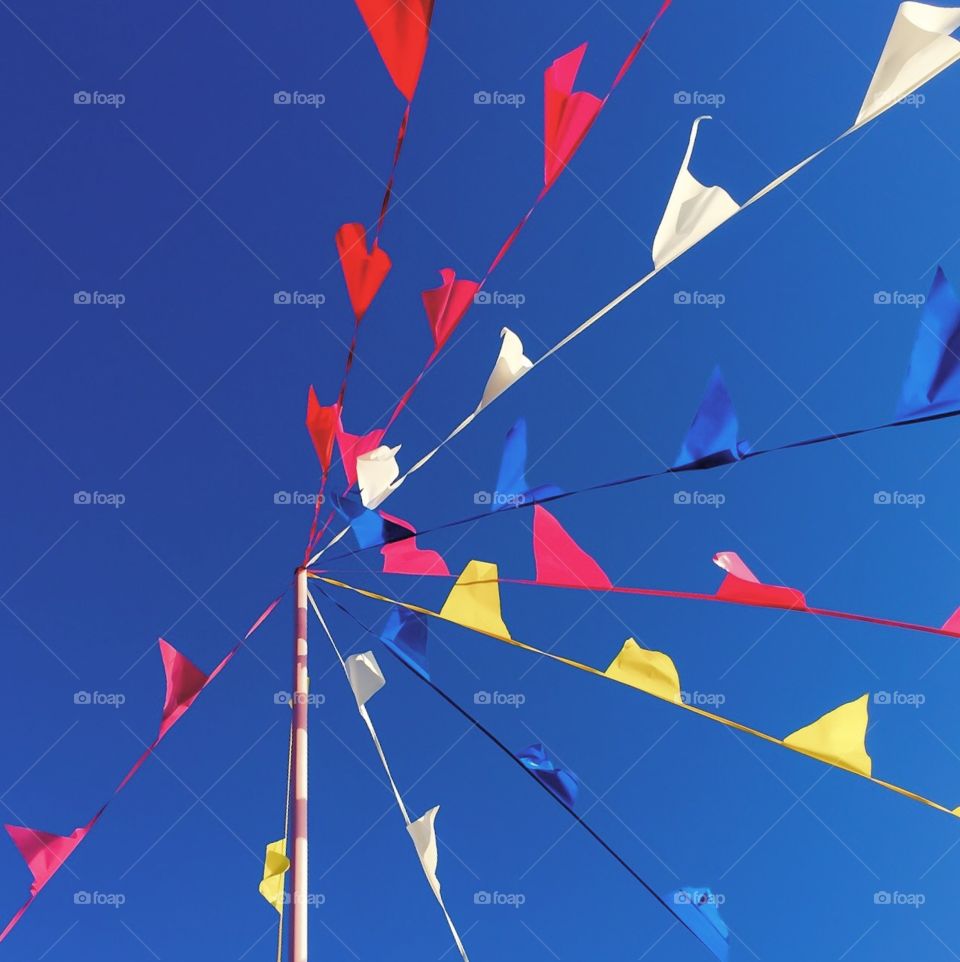 Flags on flagpole against the blue sky